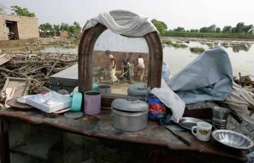 Pakistani workers are reflected on furniture as they rebuild homes in the flood-affected town of Sanawa, Punjab province, Pakistan on Thursday Sept. 2, 2010. (AP Photo/Aaron Favila) #